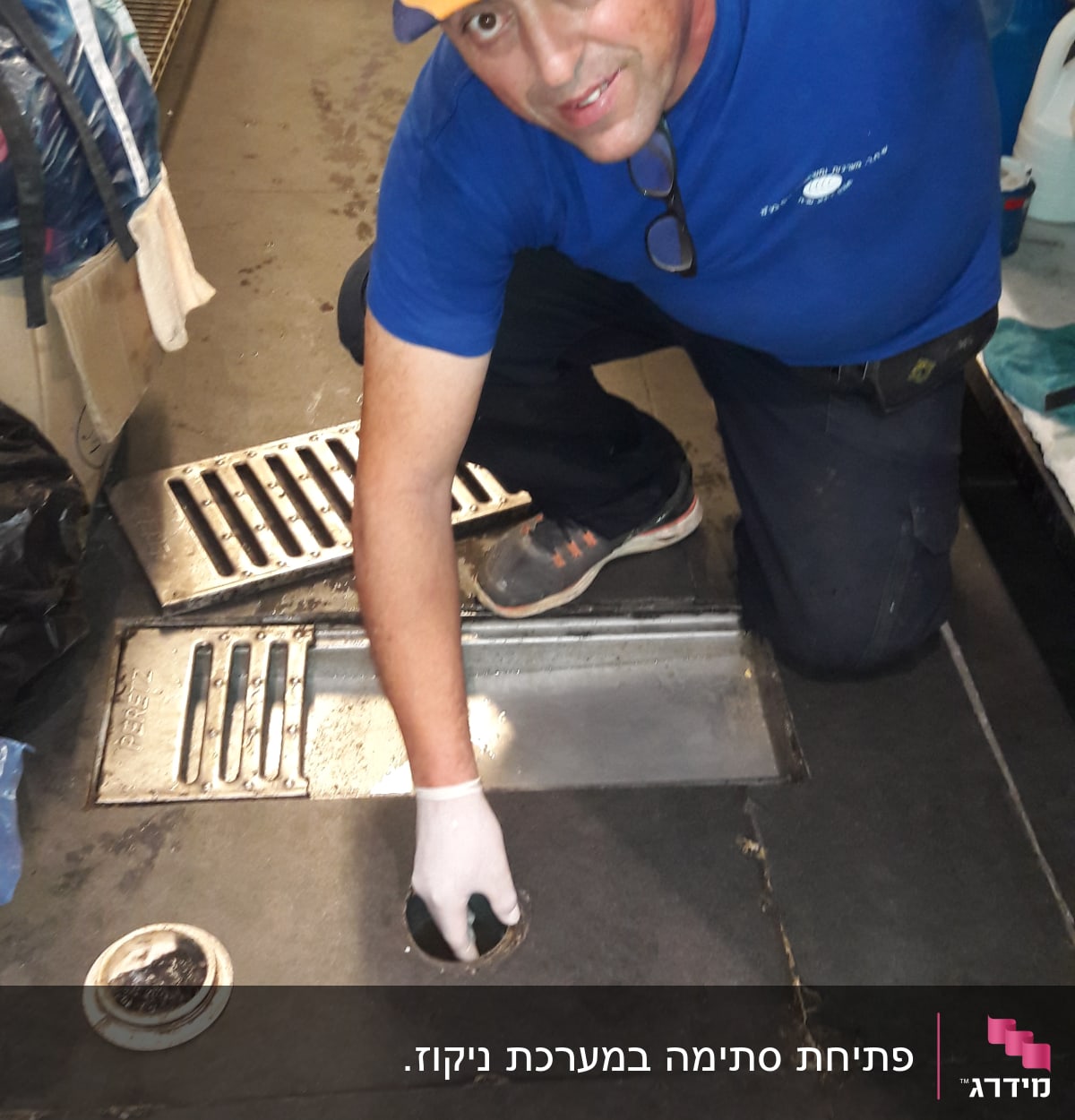 אדם עם כפפה מתקין מכסה ניקוז ברצפה